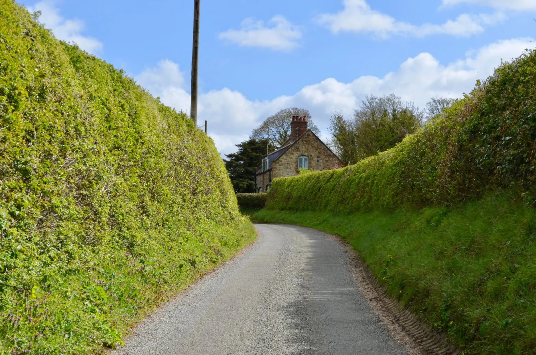 Country lane to stone cottage.