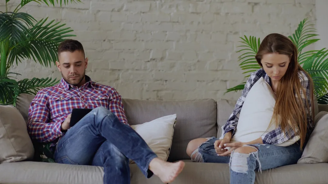 Couple comparing deals on the sofa.