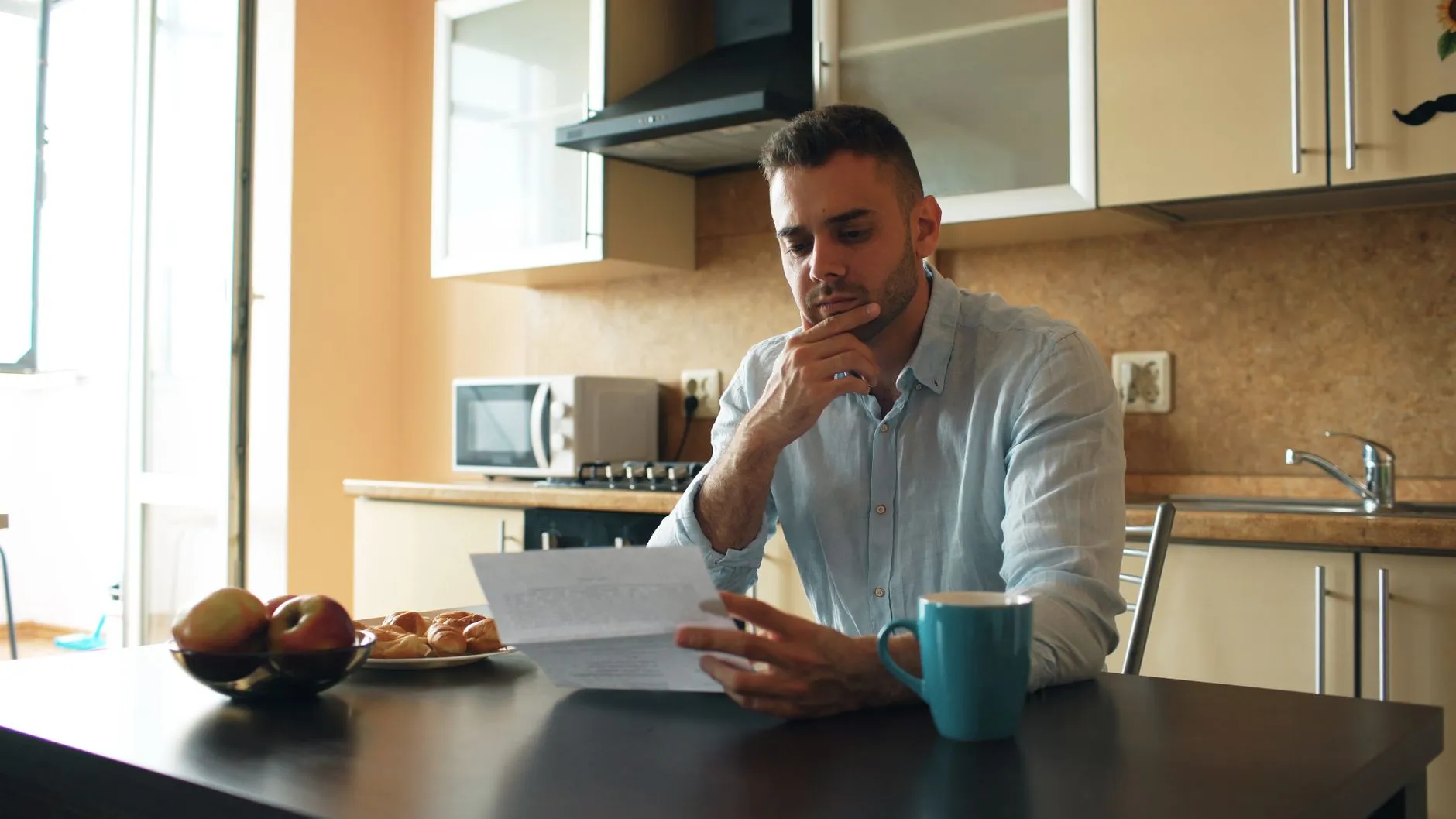 Man reading letter in kitchen